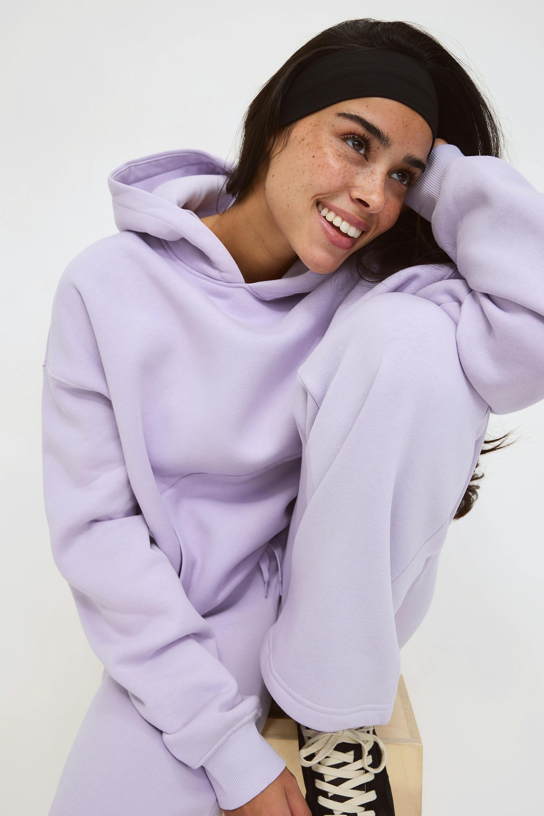 Lila överdimensionerad huvtröja med känguruficka över en vit T-shirt, tillsammans med matchande lila sweatpants med dragsko.