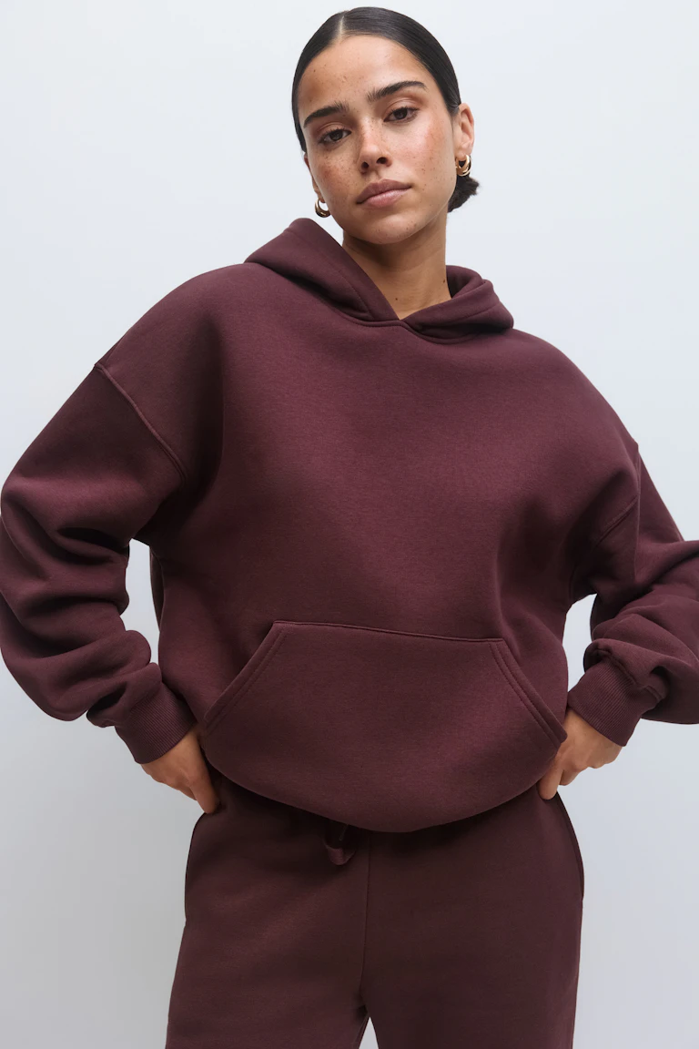 Oversized burgundy hooded sweatshirt with kangaroo pocket, paired with matching burgundy sweatpants.