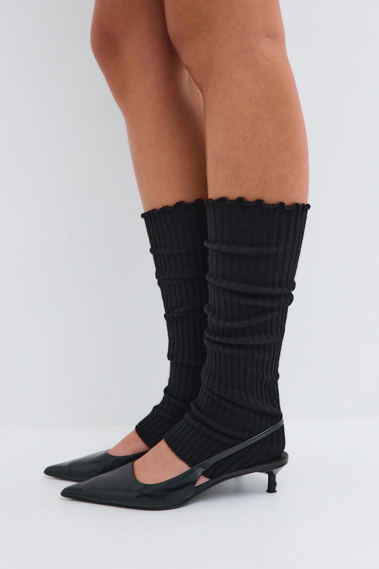 Black ribbed leg warmers with black pointed slingback kitten heels.