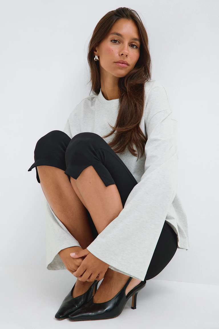 Avslappnad ljus ljunggrå crewneck med lång ärm kombinerad med blekgrå jeans med hög midja.