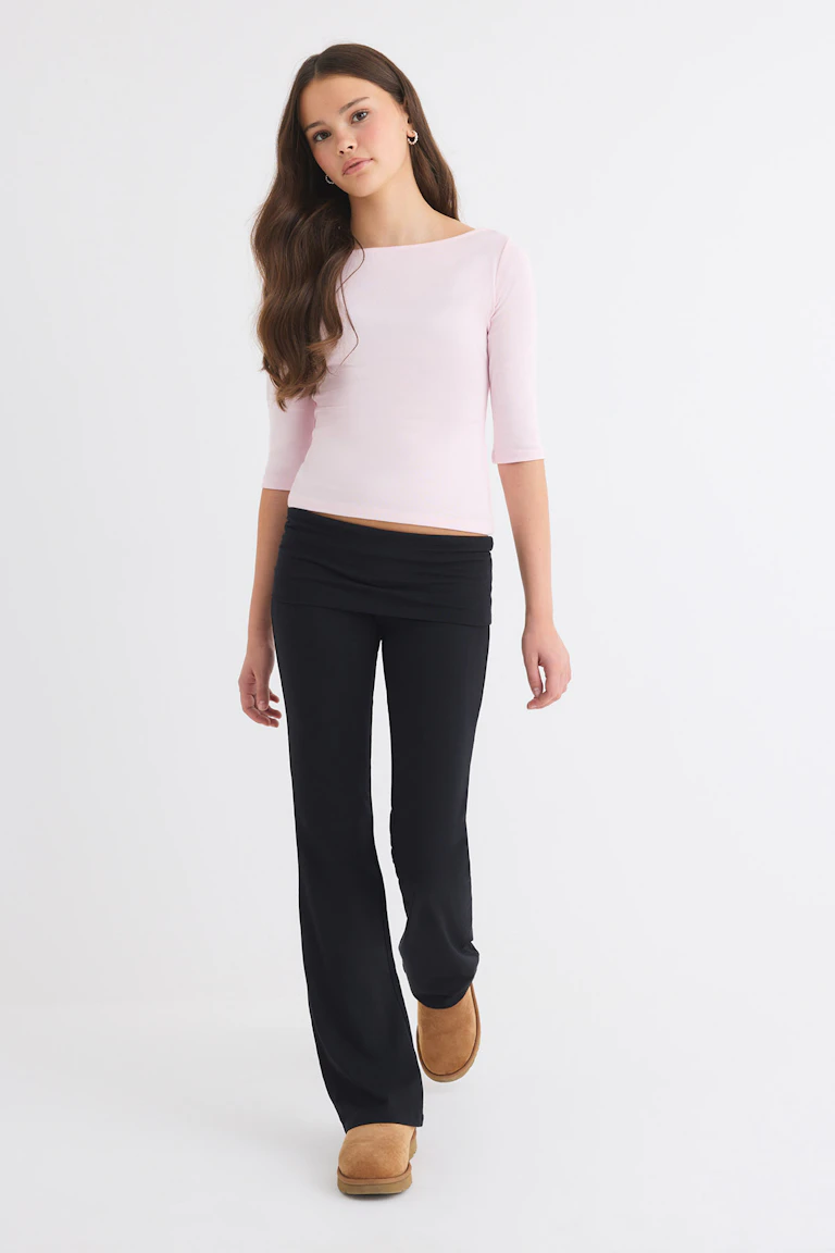 ID 77164, StyleColorSupplier 12651: Light pink three-quarter sleeve top, black flared leggings, and tan boots.