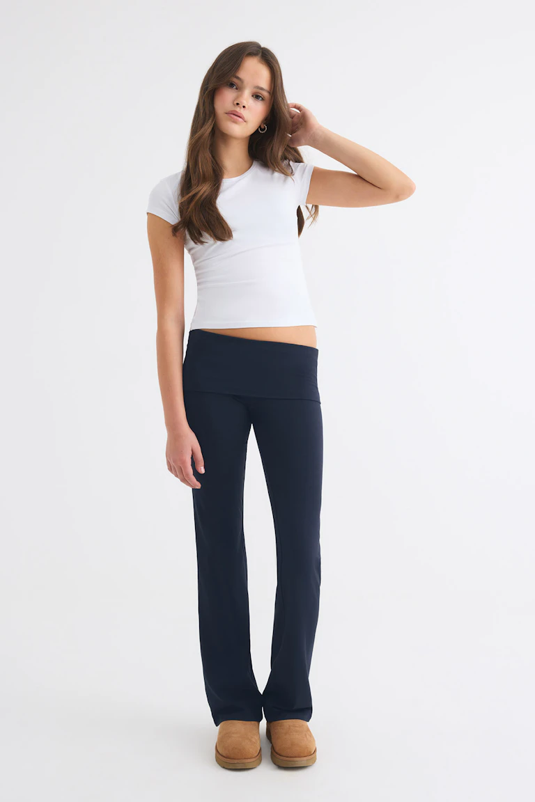 ID 77164, StyleColorSupplier 12651: white fitted short-sleeve top, navy flared trousers, and tan slip-on shoes.