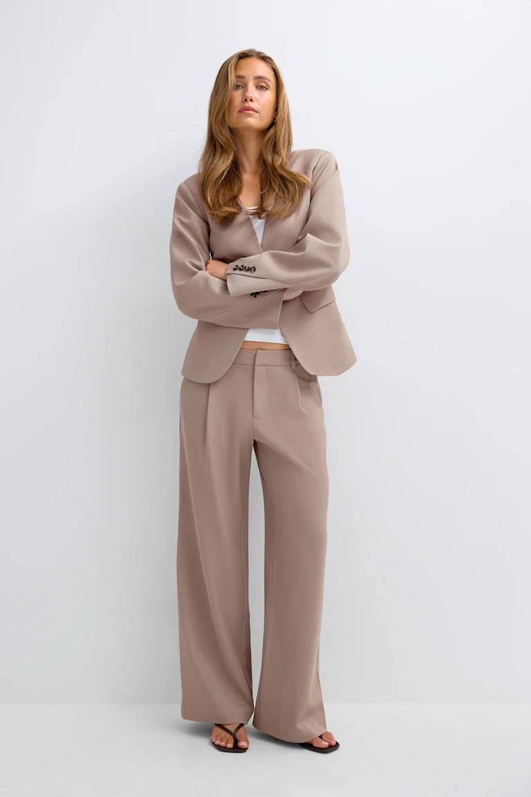Beige skreddersydd blazer med matchende bukser med vide ben.