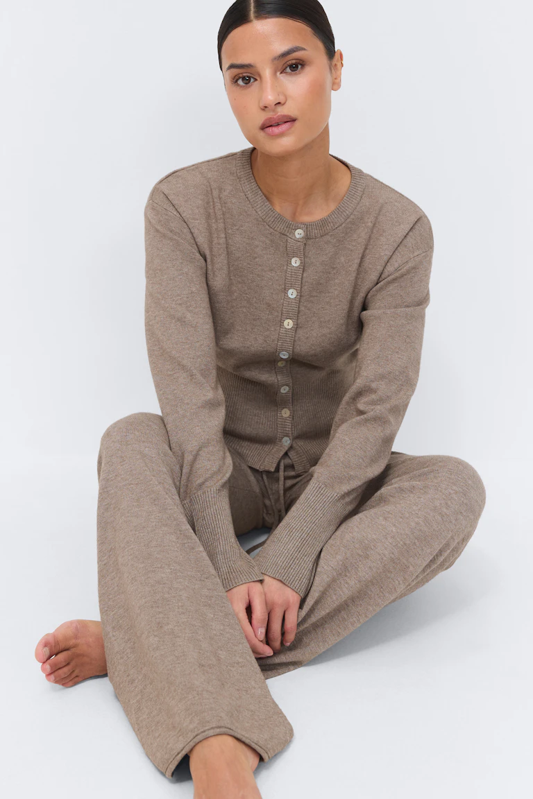 Taupe ribbed-knit button-up cardigan with long sleeves, paired with matching wide-leg drawstring knit trousers.