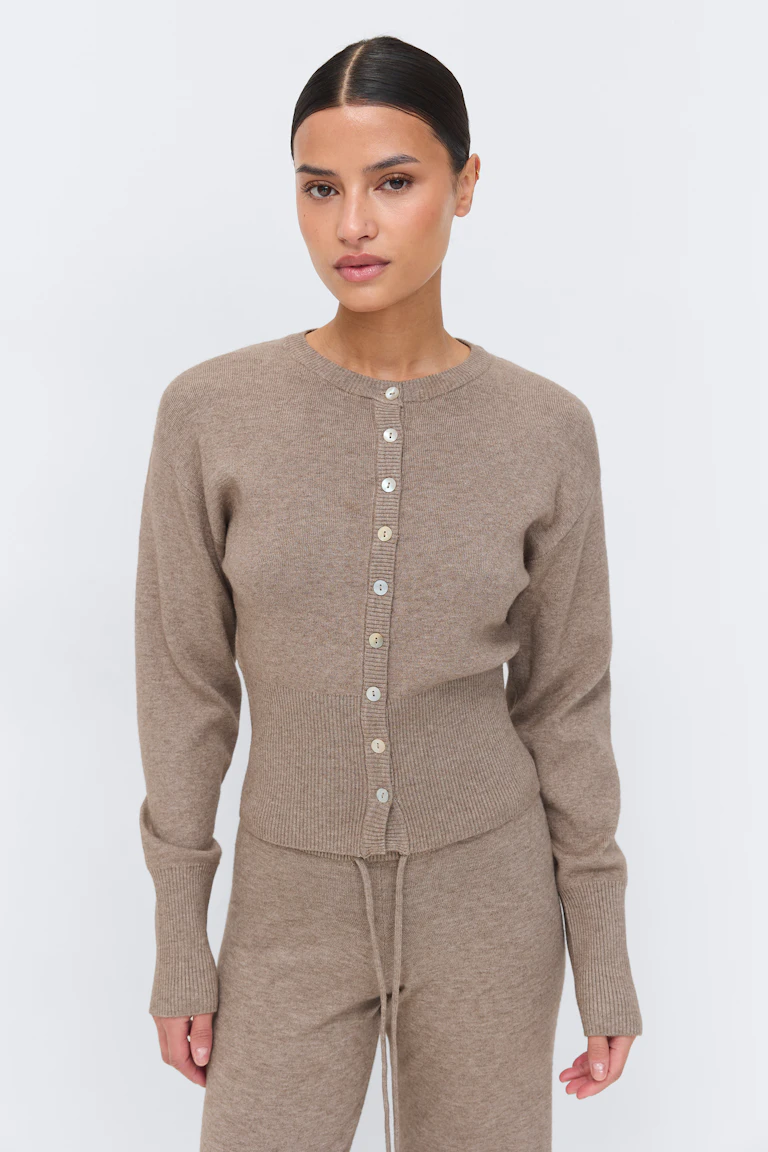 Taupefarbene, langärmelige Strickjacke mit Rundhalsausschnitt und Knopfleiste und breitem, geripptem Bund, kombiniert mit einer passenden Strickhose mit Kordelzug.