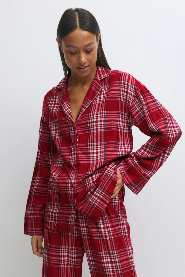 Tweedelige rood-wit geruite flanellen slaapset bestaande uit een overhemd met lange mouwen en een bijpassende relaxed-fit broek.