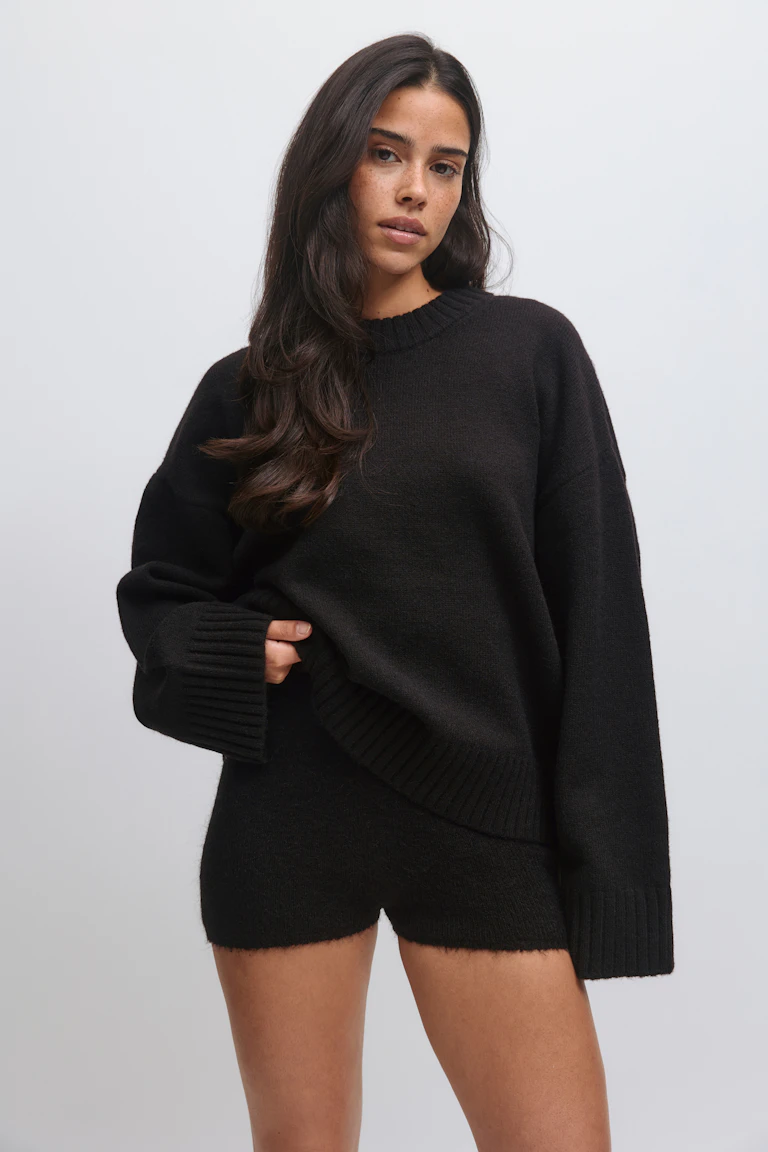 Svart överdimensionerad ribbad crewneck-tröja med långa ribbade muddar och nederkant, matchad med matchande svarta stickade shorts.