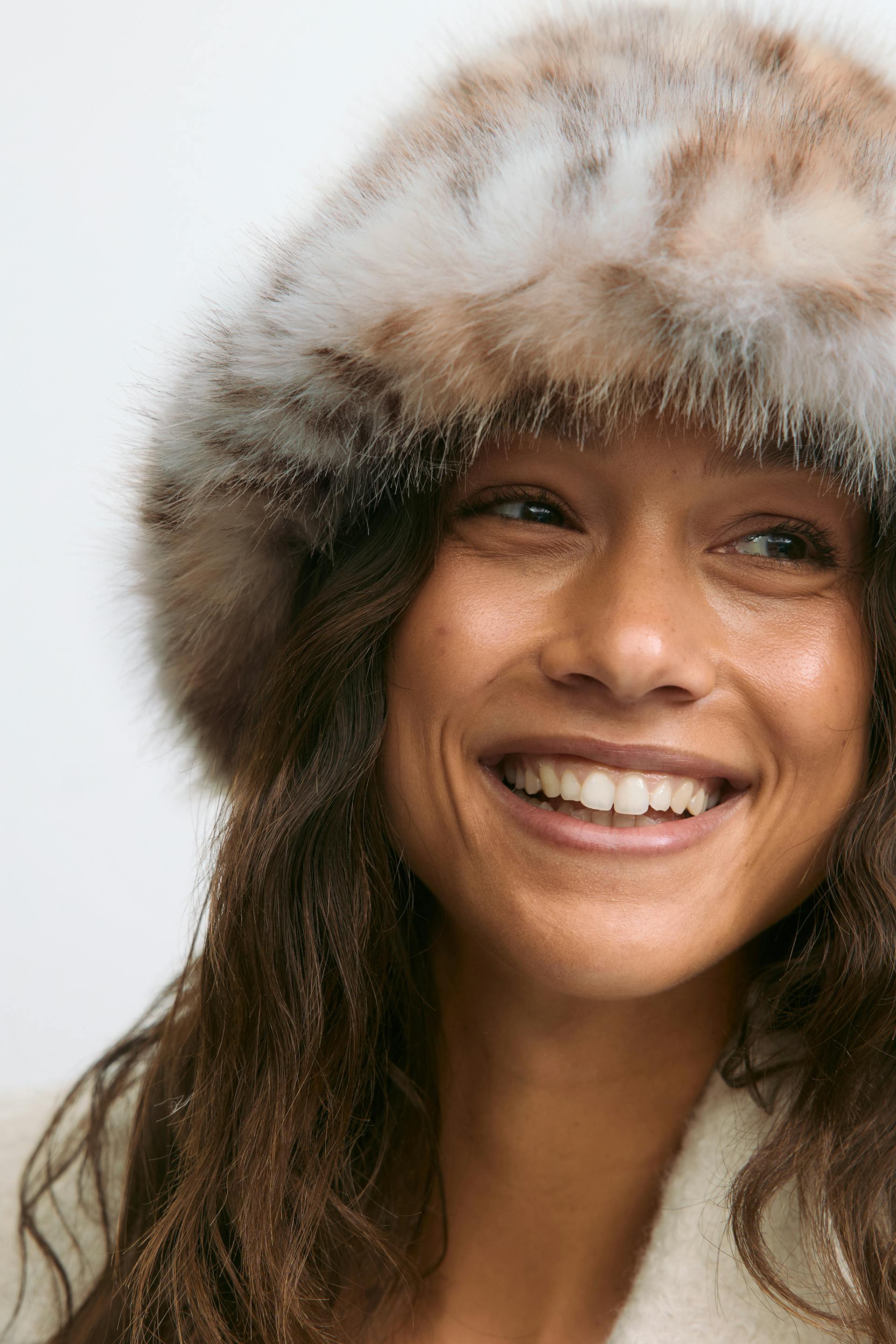 Light brown and cream fur hat paired with a cream shearling coat.