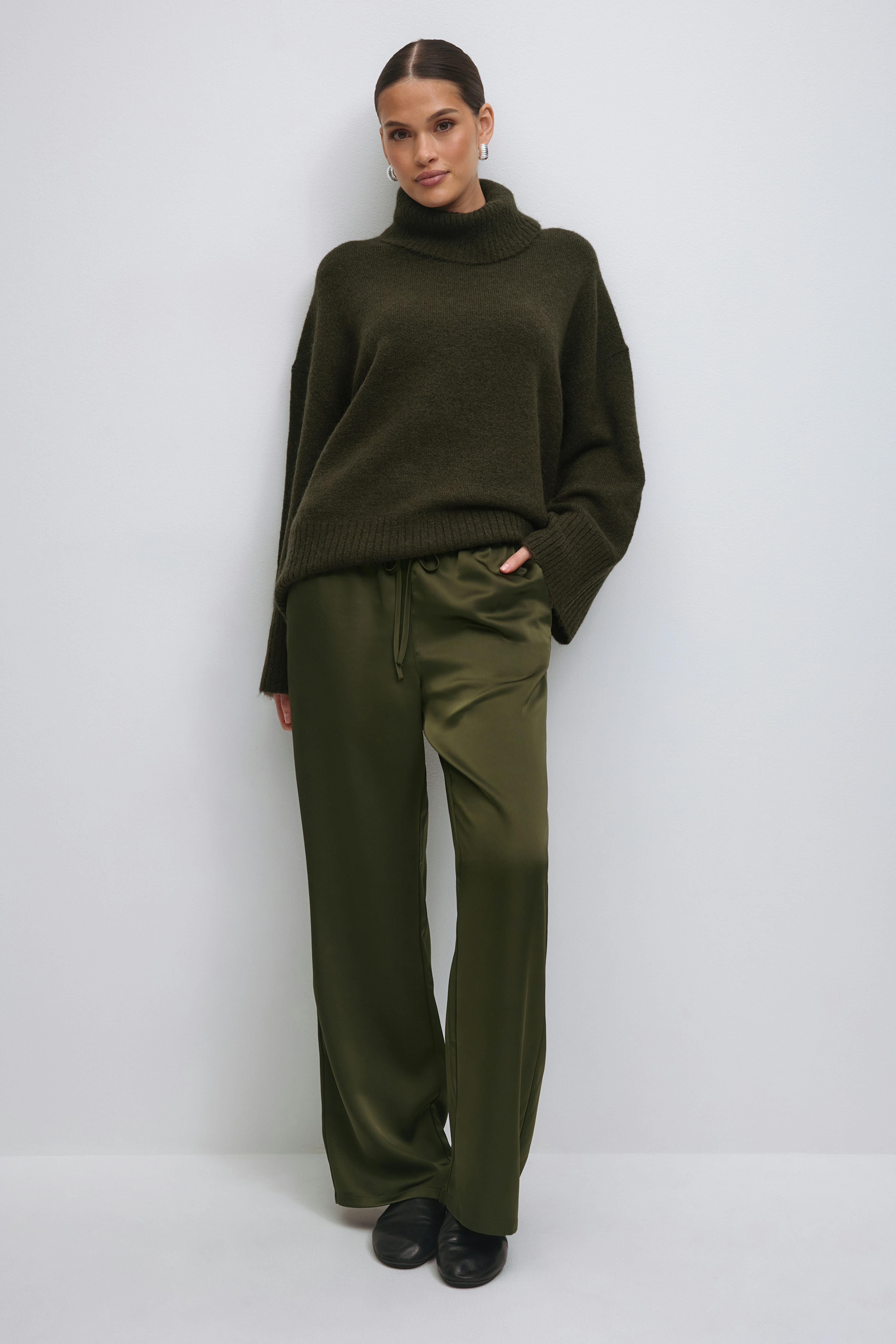 Hvid ærmeløs peplum-top sammen med olivengrønne satinbukser med bred snøre og cremefarvede ballerinaer med læg.