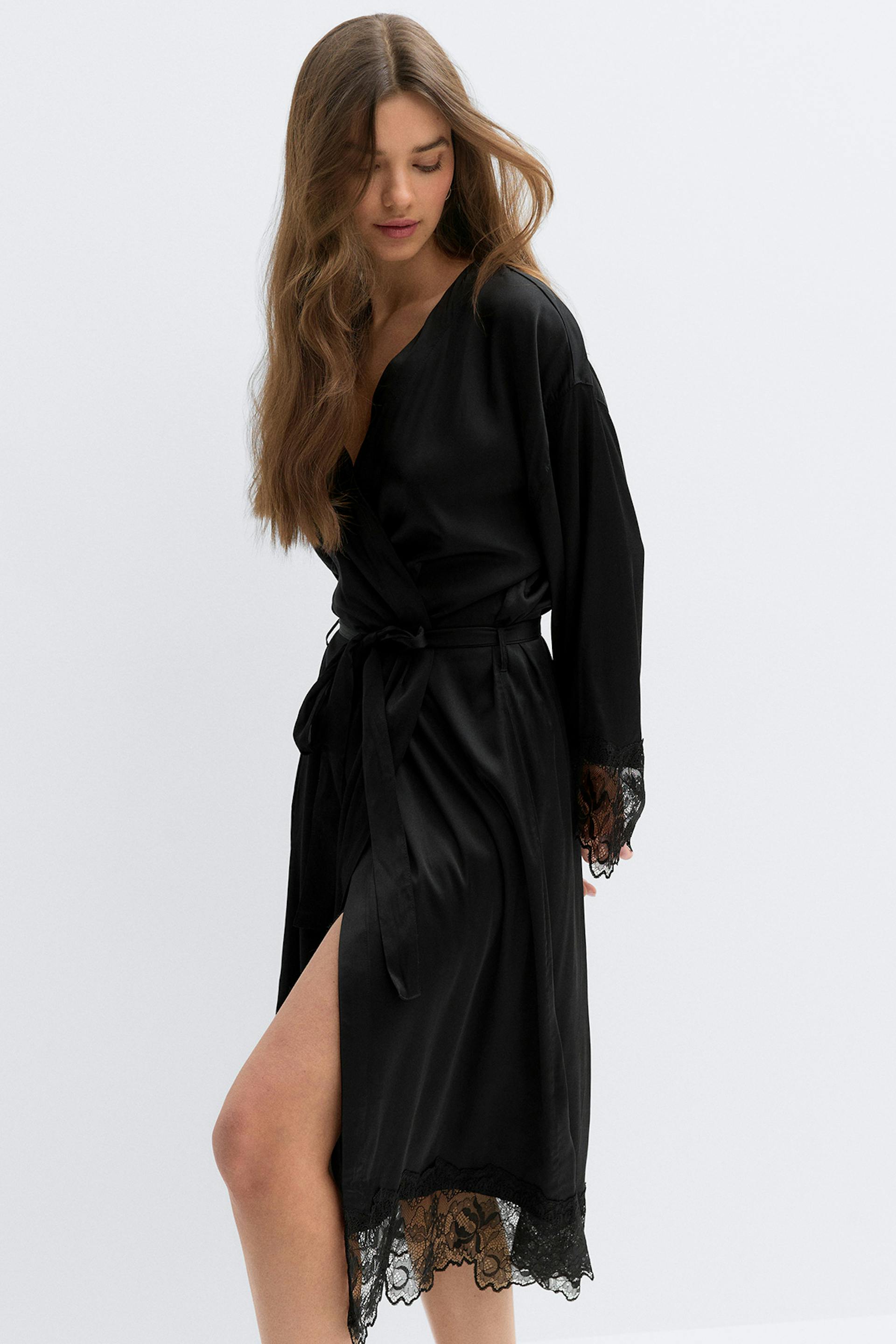 Black satin long robe with lace-trimmed cuffs and hem, worn over a matching black camisole and lace-trim shorts.
