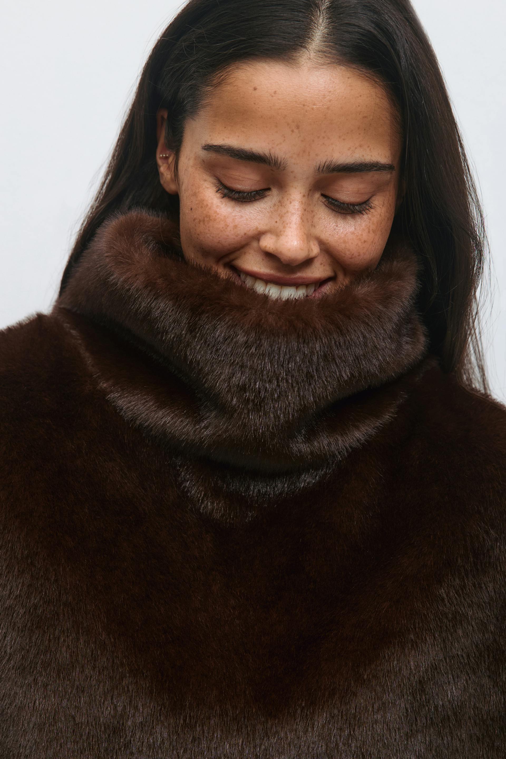 Dark brown fur coat with a high, plush funnel neckline.