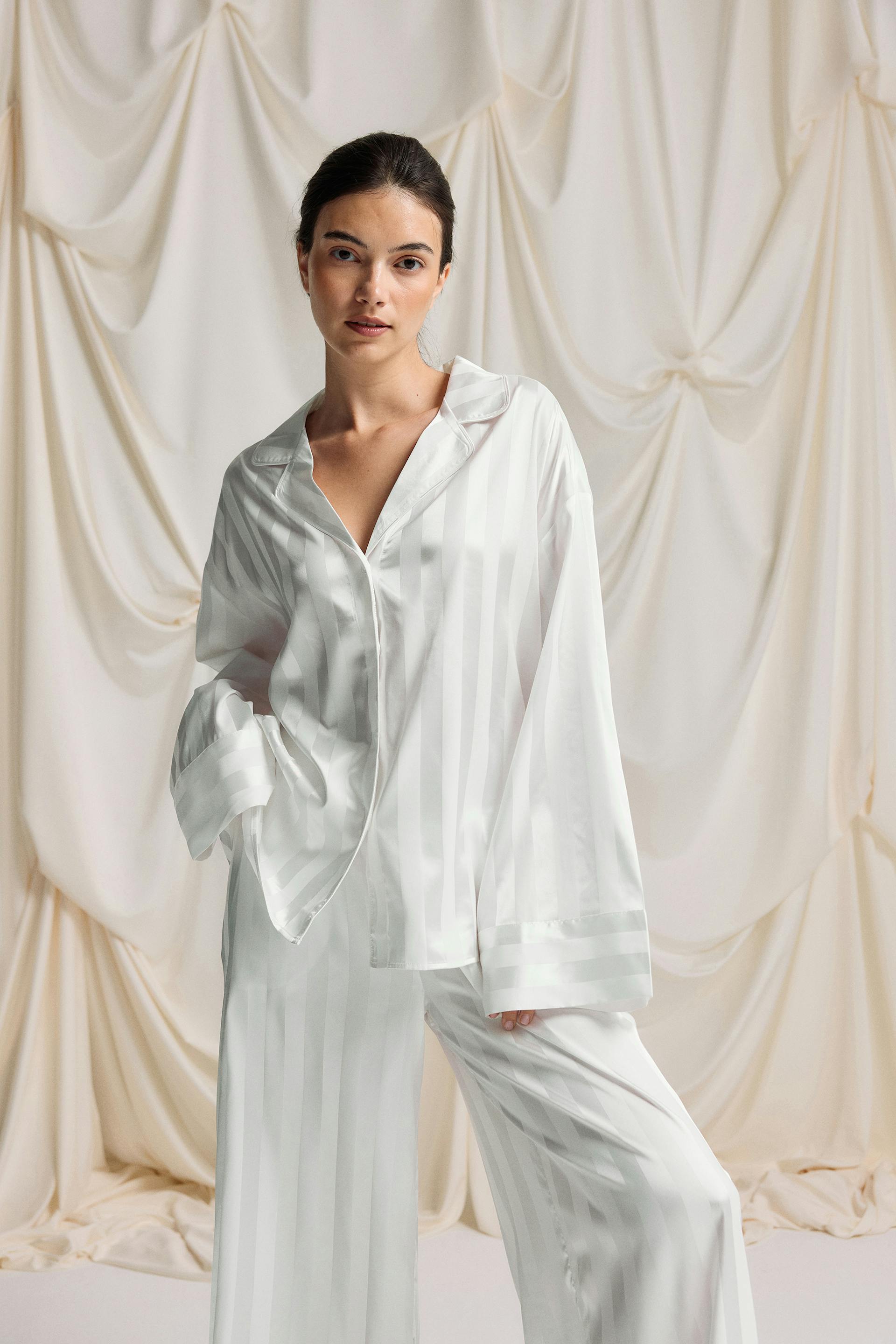 Weißes Pyjama-Set in Satin-Optik mit tonalen Längsstreifen: Langarmhemd zum Knöpfen mit gekerbtem Kragen und passende Hose mit weitem Bein.