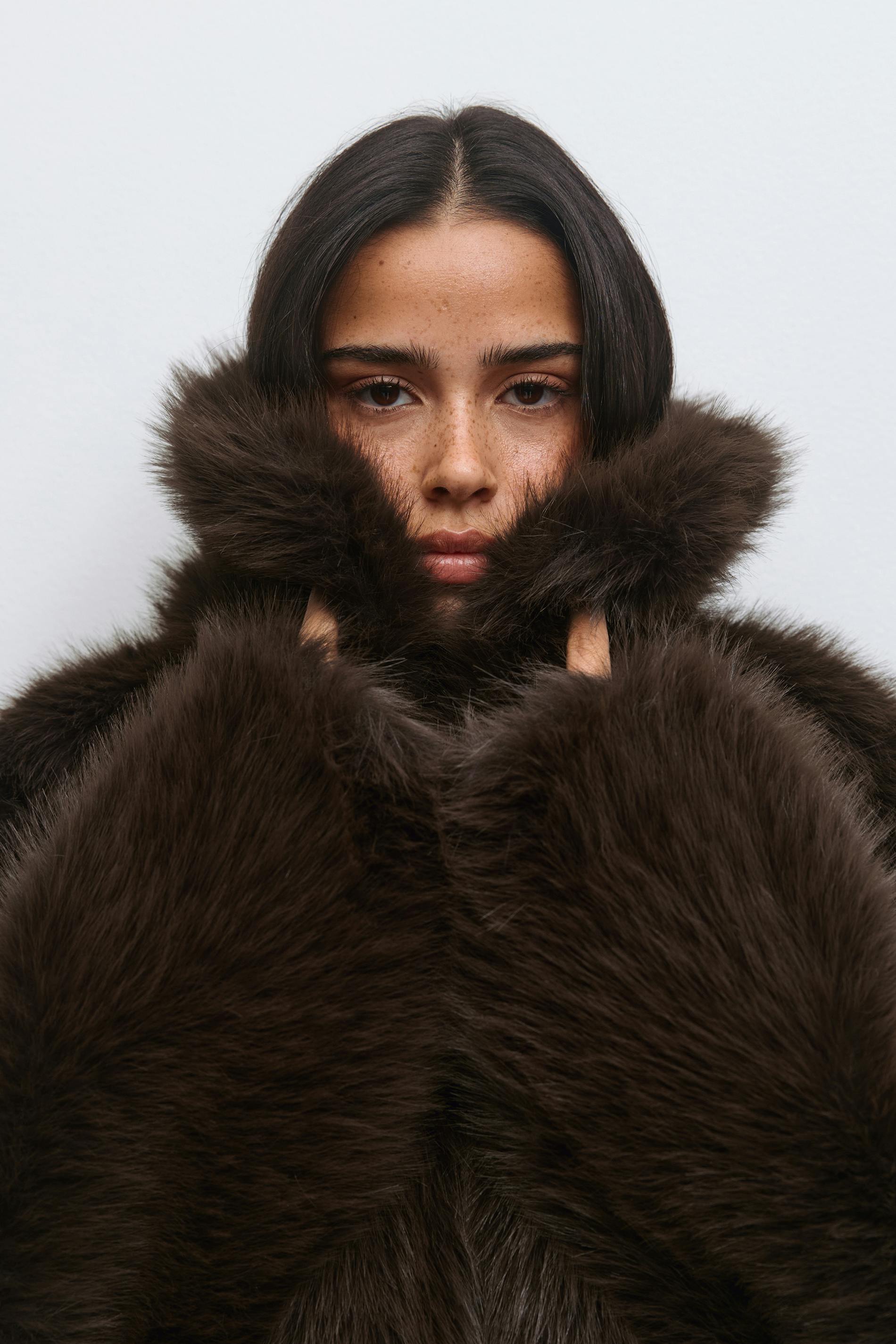 Manteau de fourrure en peluche brun chocolat foncé avec un col montant surdimensionné et des manches longues.
