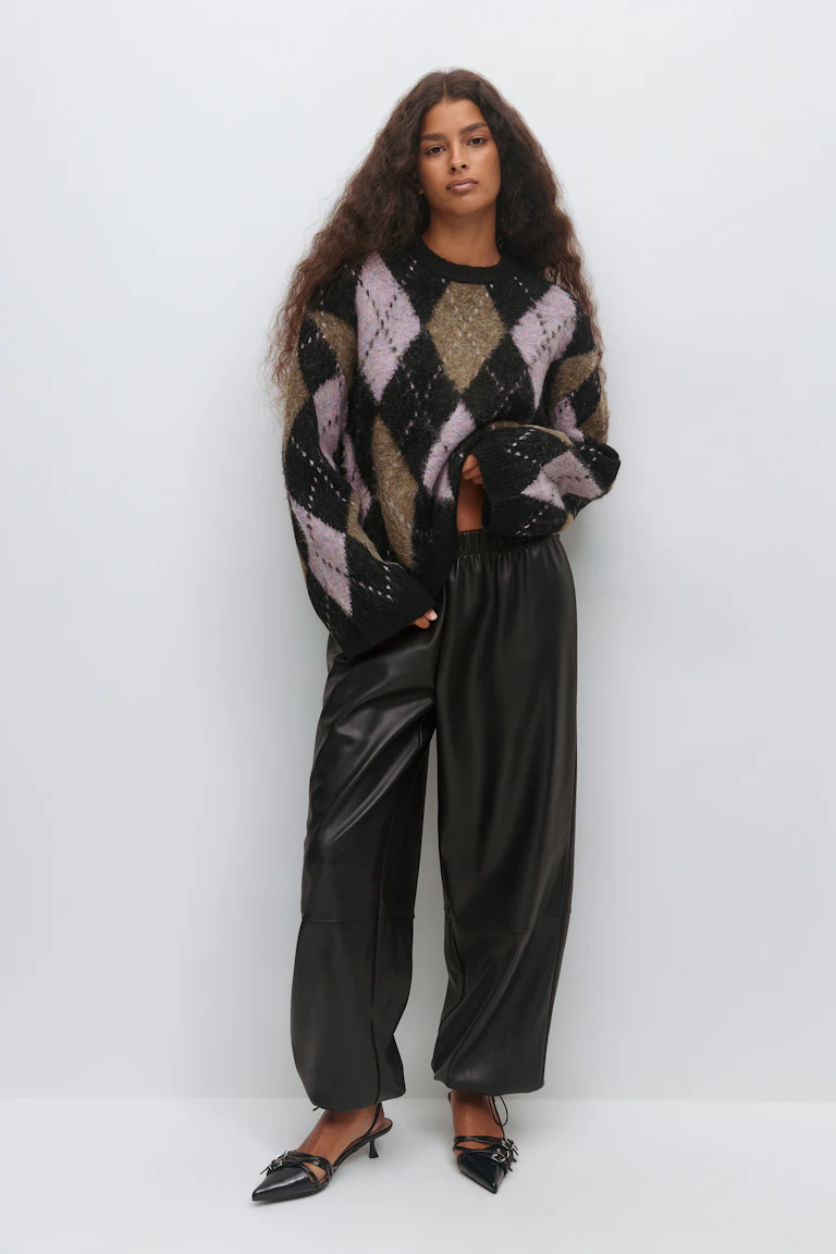 Oversized fuzzy argyle sweater in black, lilac and olive, black faux‑leather wide‑leg trousers with elastic waistband, and black pointed‑toe slingback kitten‑heel shoes with strap detailing.