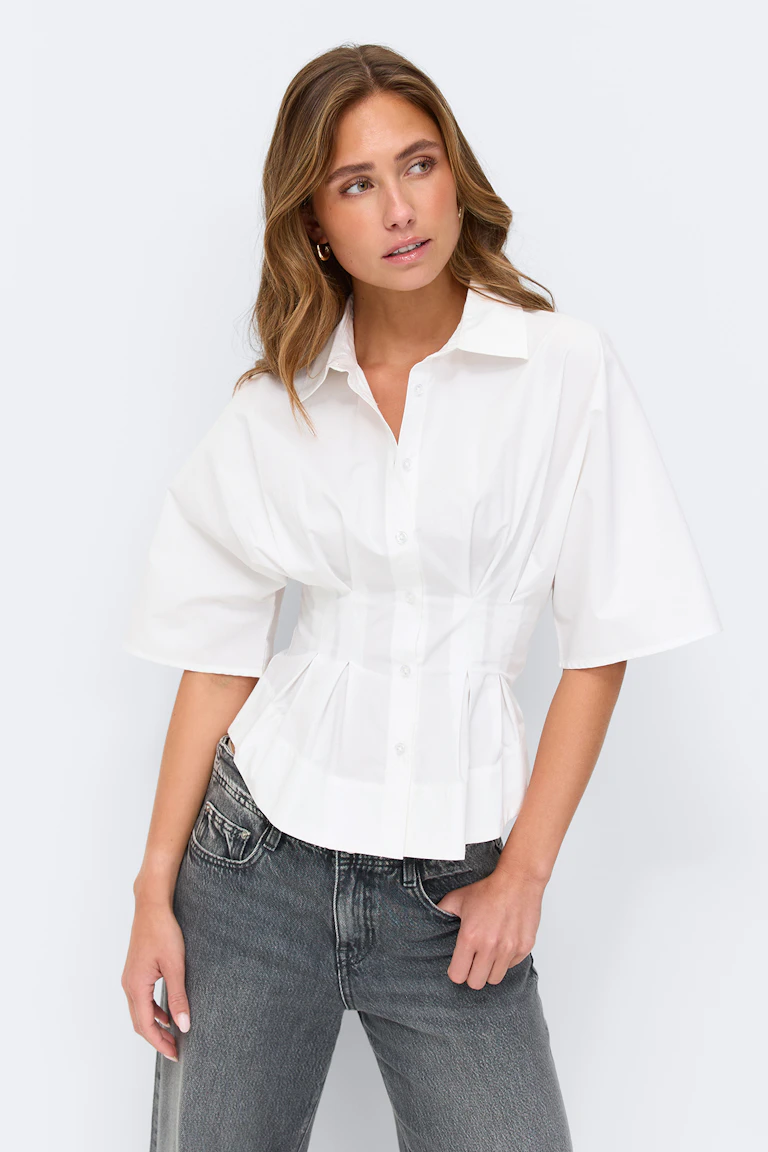 White short-sleeve button-front blouse with a structured, cinched waist and pleat detailing, paired with light-wash high-rise straight-leg jeans.