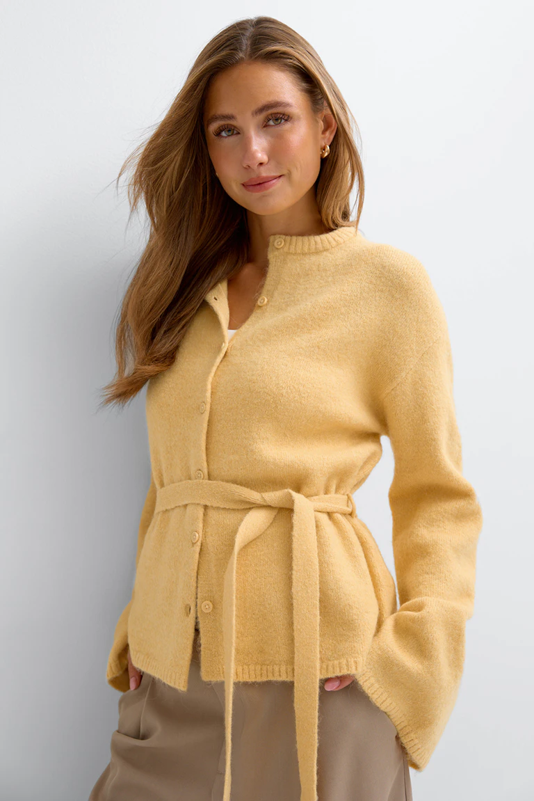 Light yellow belted cardigan with button front.