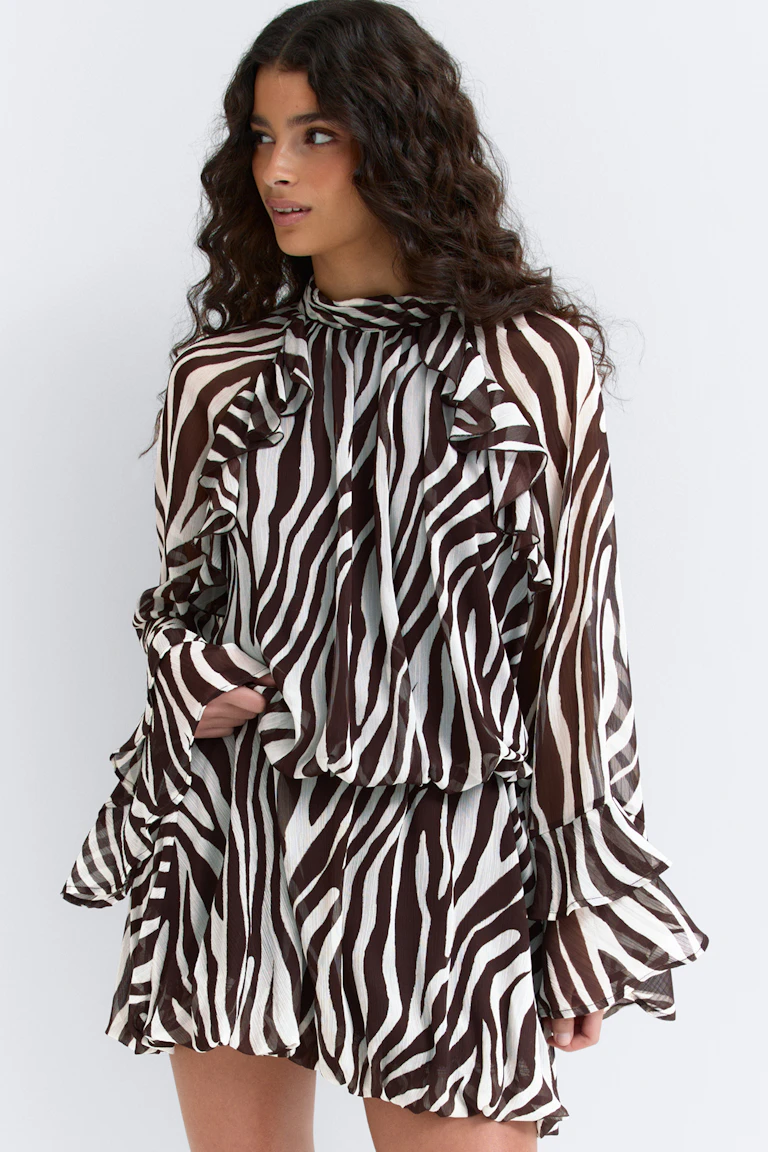 Braun-weißes langärmeliges Minikleid aus Chiffon mit Zebradruck, hohem gerafftem Ausschnitt, Blouson-Taille und Rüschendetails an Schultern, Manschetten und Volantsaum.