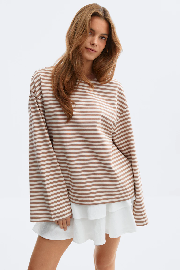 Vare nr. 310064, StyleColorSupplier 12651: Oversized langærmet bluse i beige og hvide striber med en hvid lagdelt nederdel.
