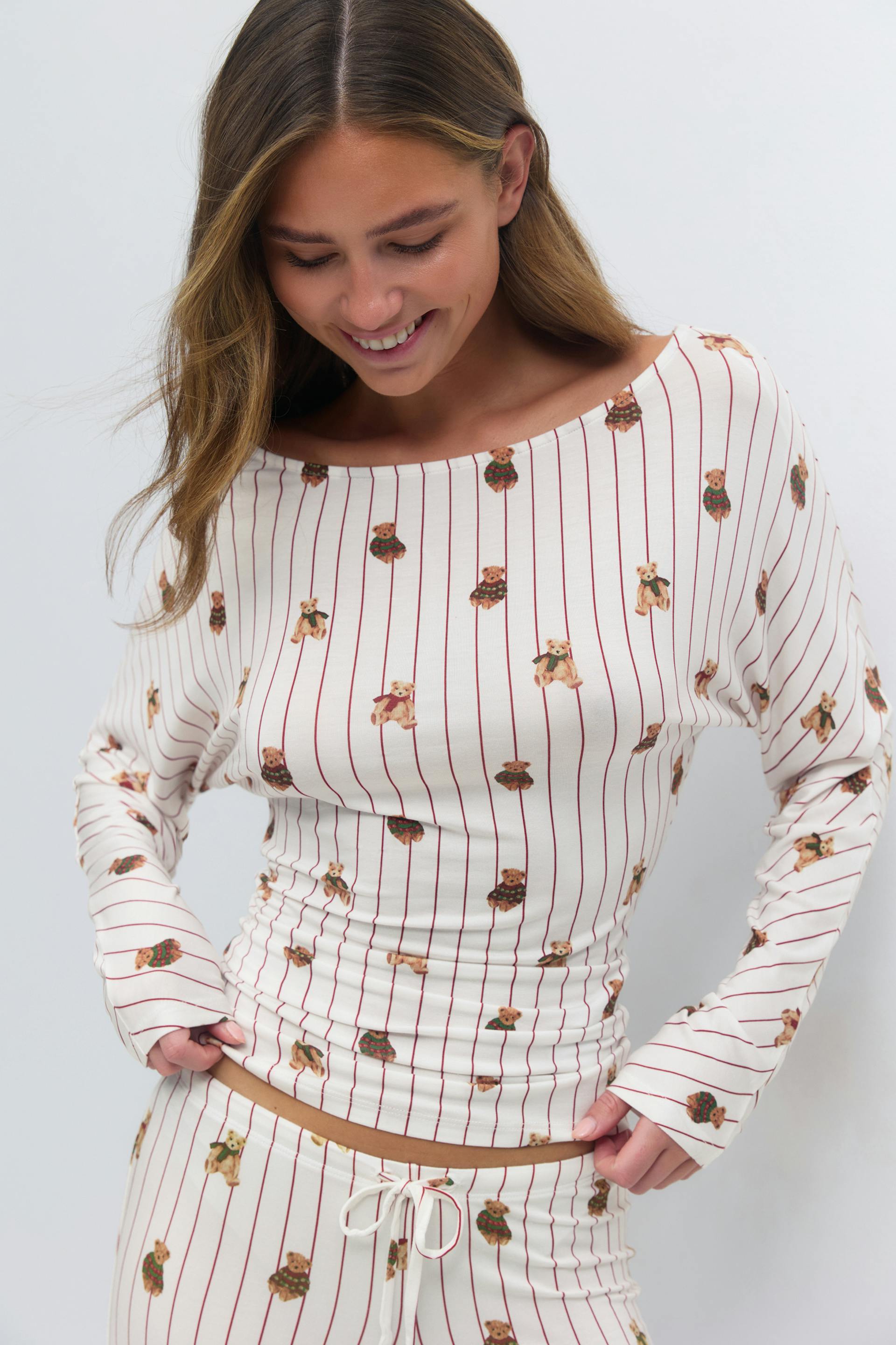 Krämfärgad långärmad båtringad topp och matchande loungebyxor med dragsko och tunna röda vertikala ränder och utspridda teddybjörnsmotiv.