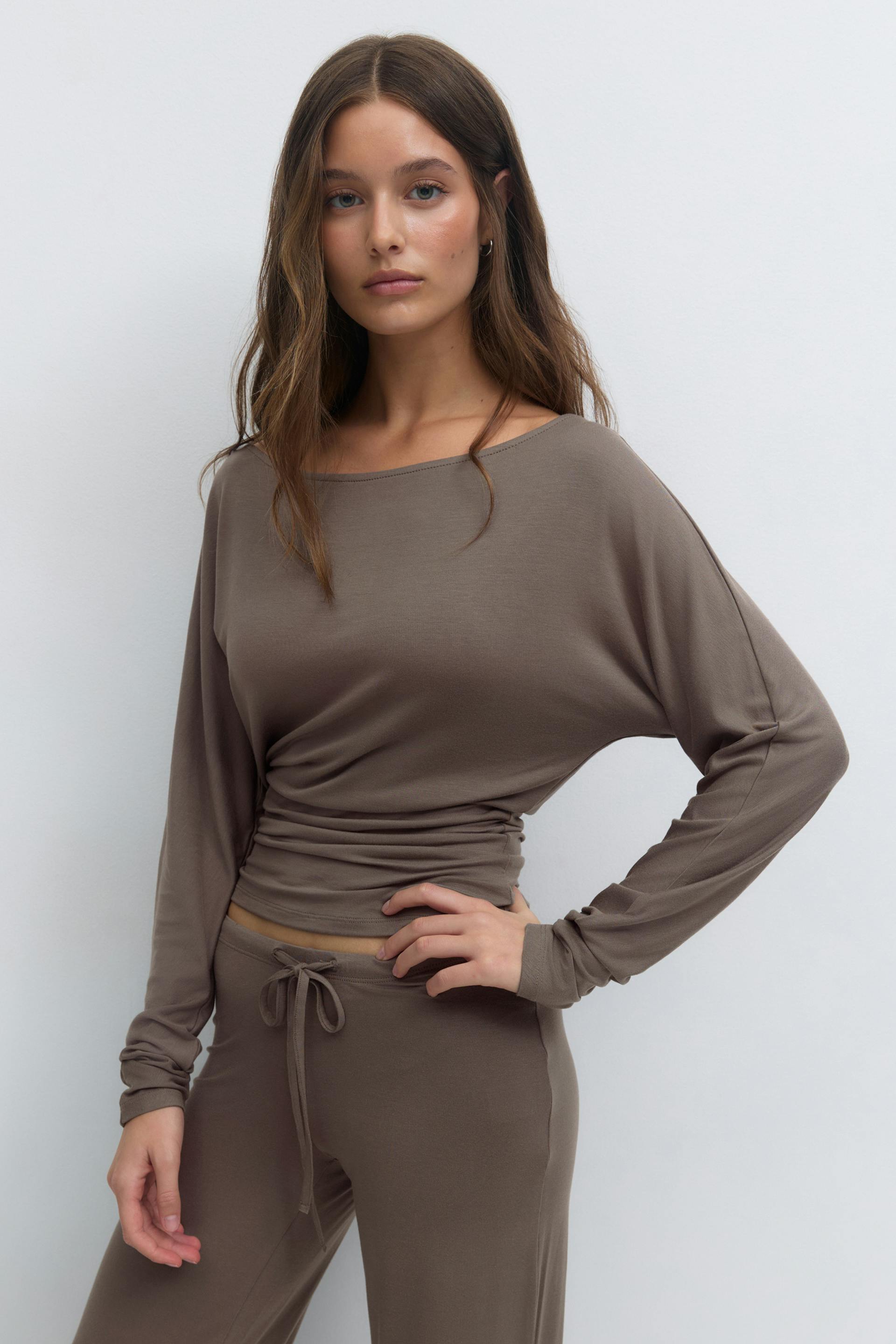 Taupe long-sleeve boat-neck top with a ruched waist, paired with matching drawstring wide-leg pants.