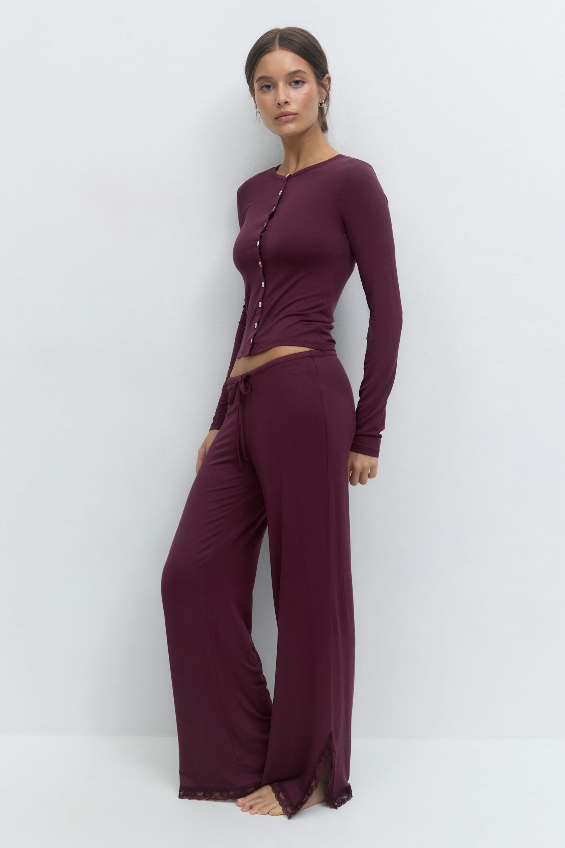 Fitted deep-plum long-sleeve button-front top paired with matching wide-leg drawstring trousers with lace-trimmed hems.