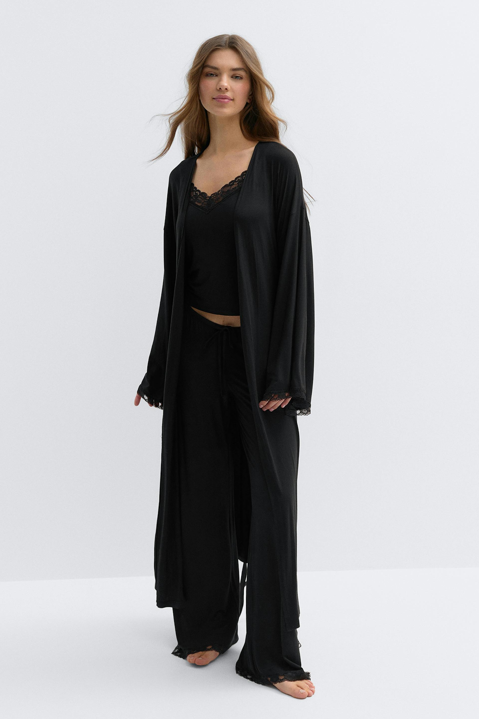 Svart golvlång omlottrock med vida kimonoärmar, självknytande midja och fina spetsar i ärmslut och sidoslits.
