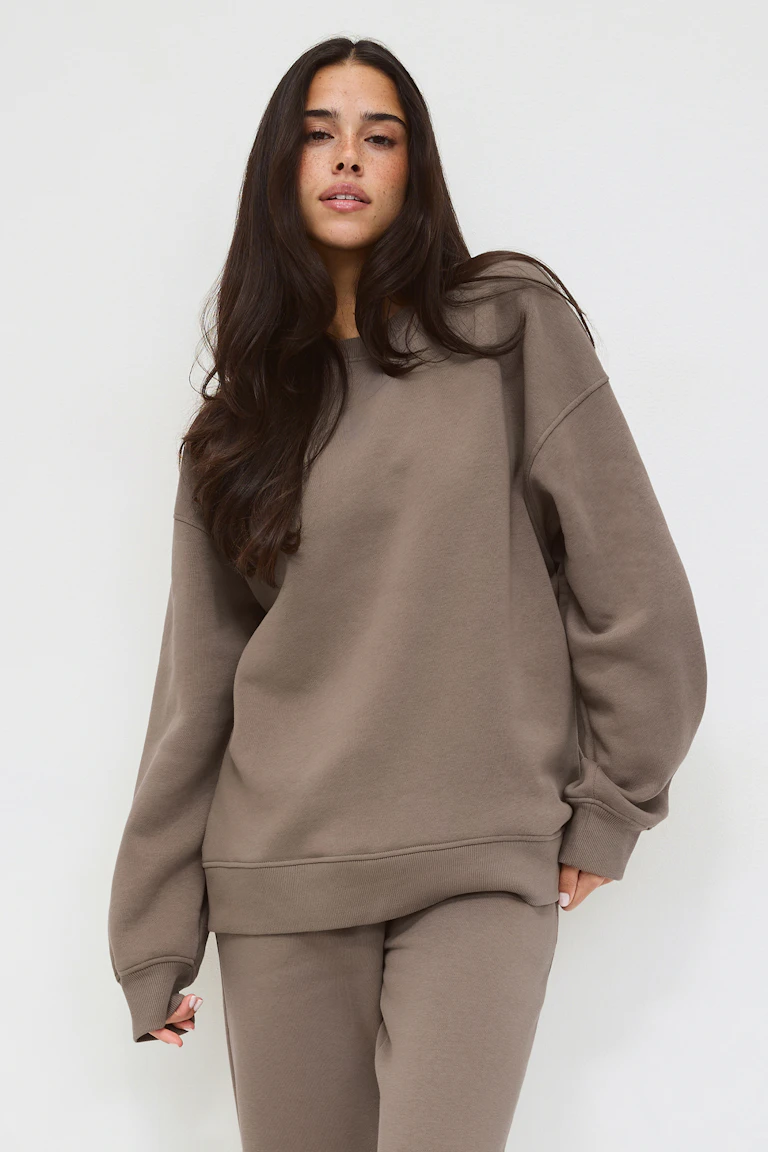 Oversized sweatshirt med crewneck och ribbade muddar i manschetter och nederkant i taupe, kombinerad med matchande joggingbyxor i taupe.