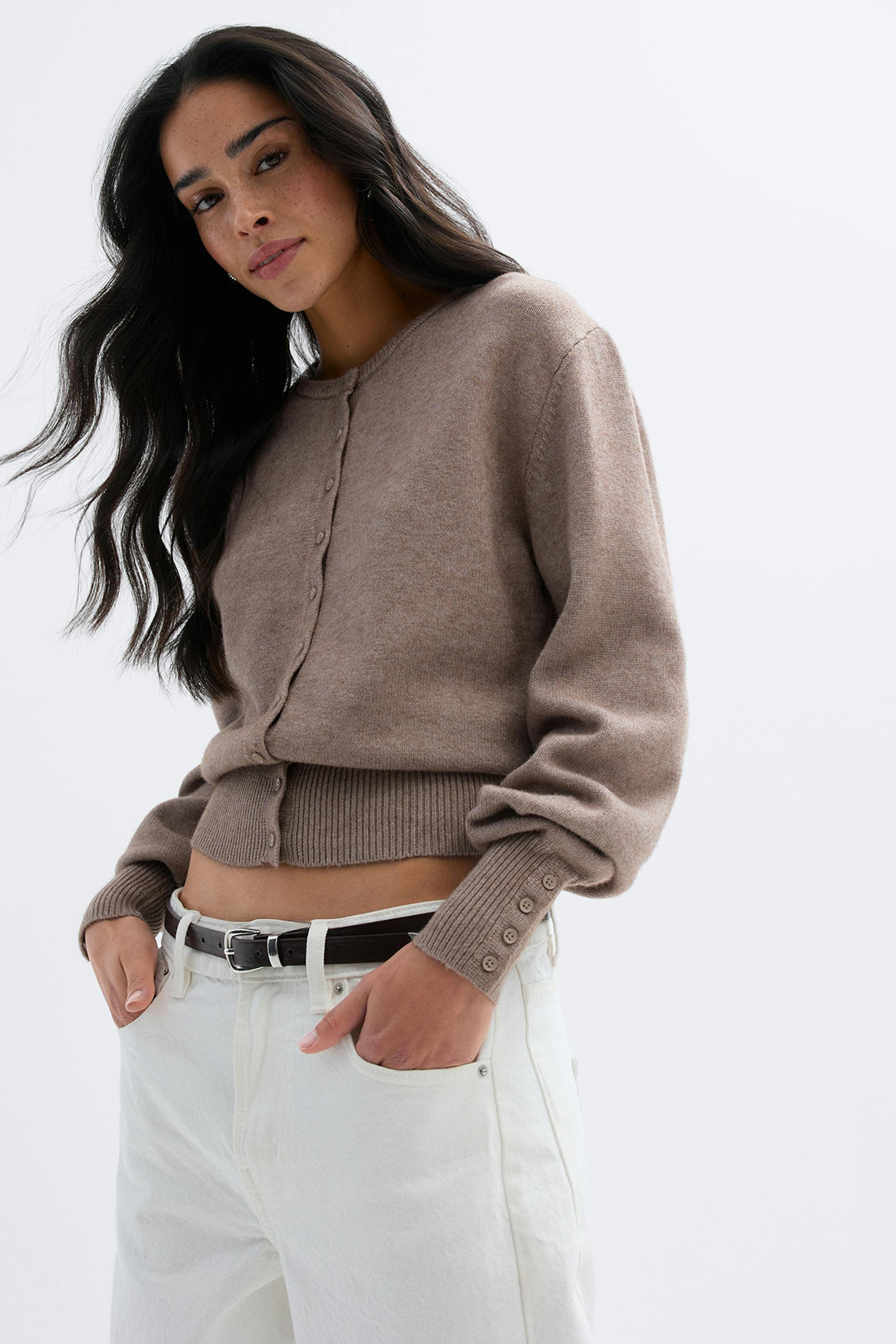 Taupinvärinen, napitettu, raidallinen neuletakki, jossa on uurrettu helma ja napitetut pallomansetit, yhdistettynä korkeavyötäröisiin, luonnonvalkoisiin farkkuihin ja tummanruskeaan nahkavyöhön, jossa on hopeasolki.