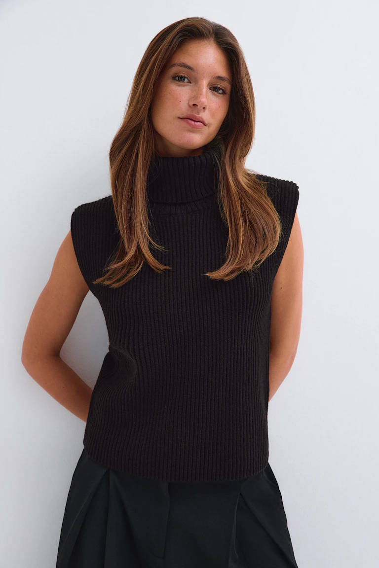 ID 320816, StyleColorSupplier 17490: Svart, ribbad, ärmlös tröja med hög hals och svarta byxor.