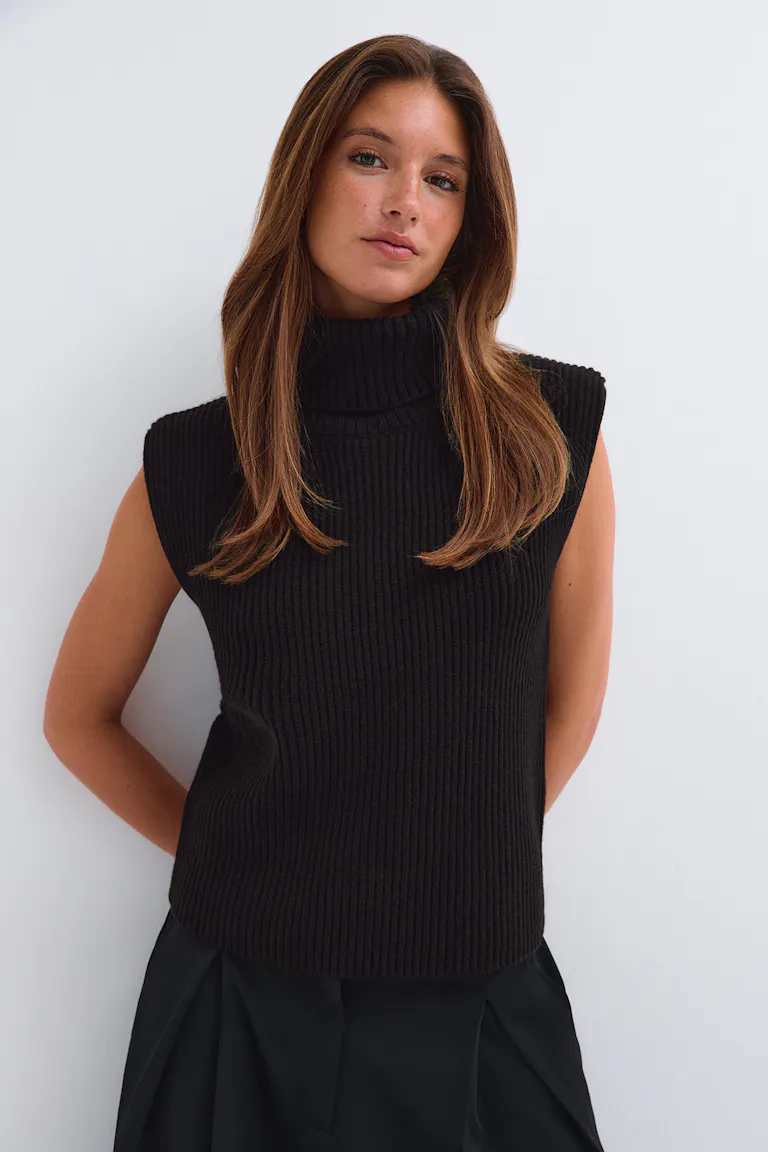 ID 320816, StyleColorSupplier 17490: Sort, ribbet, ærmeløs top med høj hals og sorte bukser.