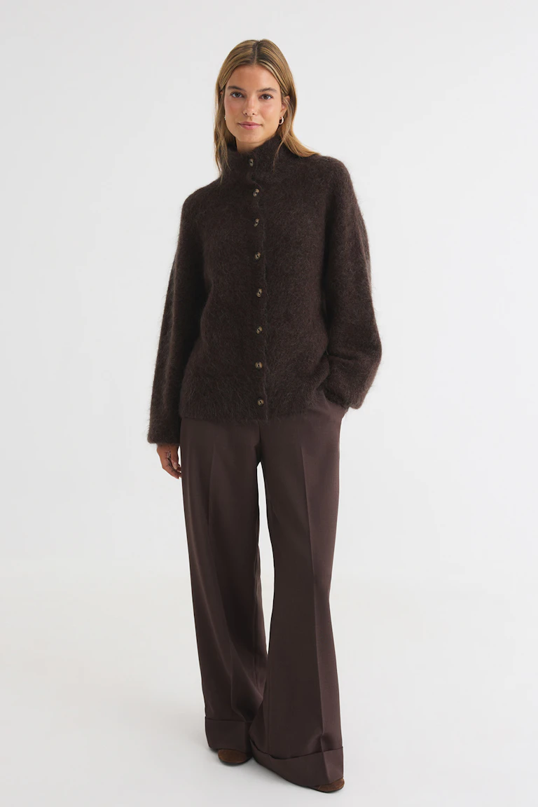 Dunkelbraune Strickjacke mit Knopfleiste vorne und dazu passender Hose mit weitem Bein.