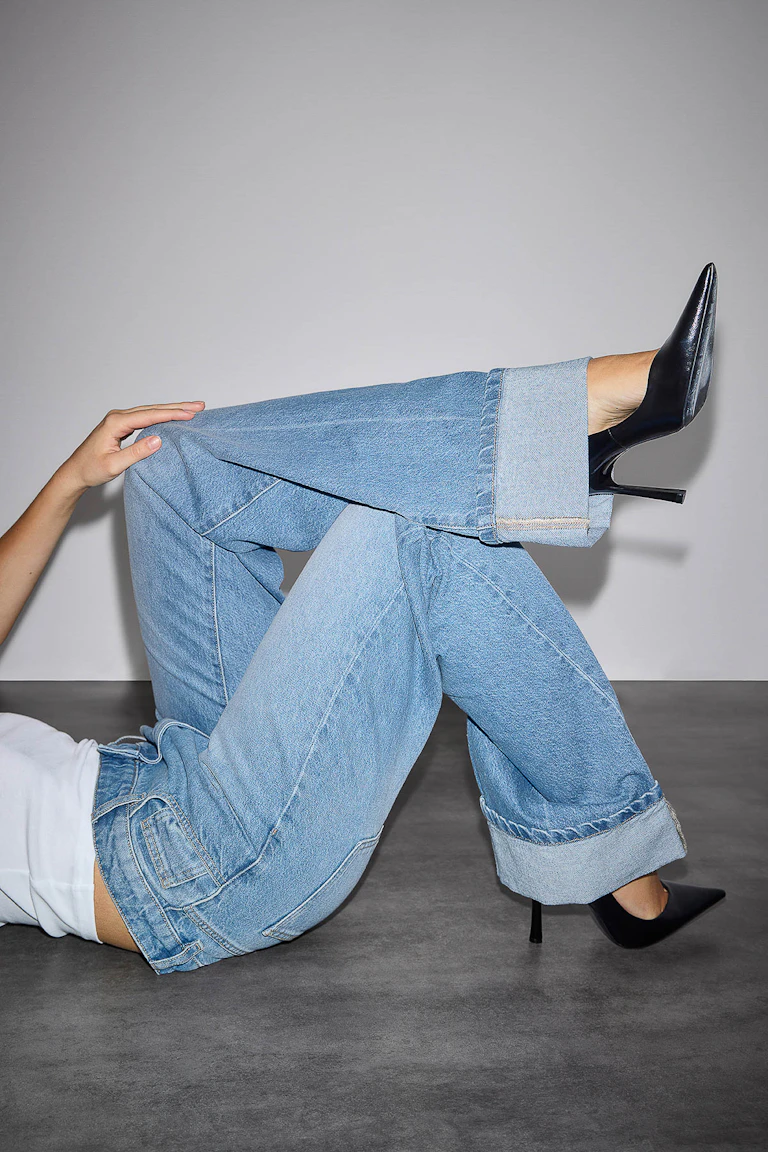 Vitt figursytt linne, ljusa tvättade jeans med vida ben och svarta spetsiga stilettklackar.