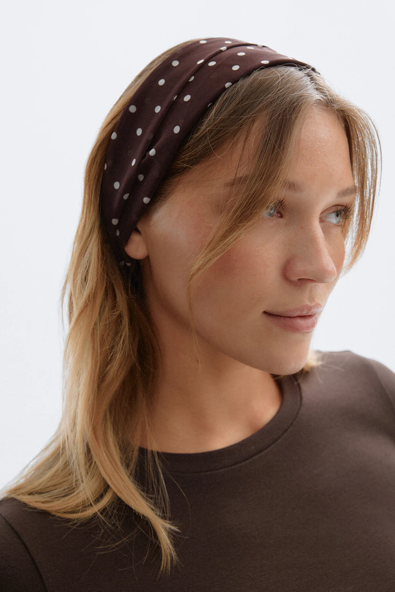 Donkerbruin T-shirt met ronde hals en een brede bruine hoofdband met witte stippen.