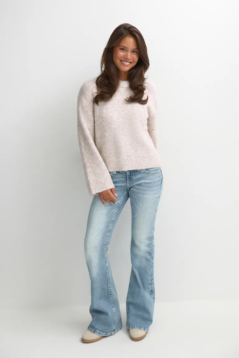 Un pull en maille légère avec un jean évasé.