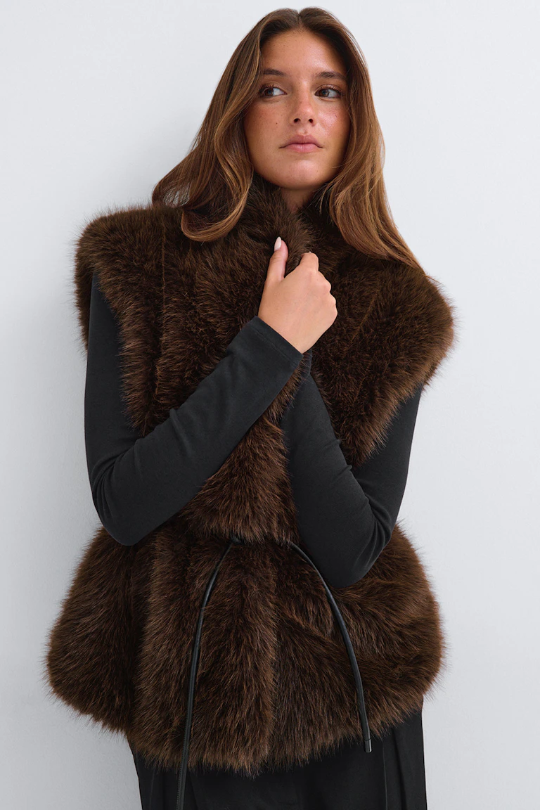 ID 331422, StyleColorSupplier 16780: Black long-sleeve dress with a brown faux-fur vest and waist tie.
