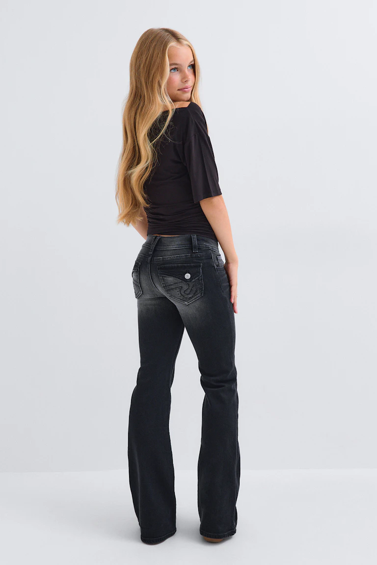 Zwarte top met korte mouwen en een donkere flared jeans.