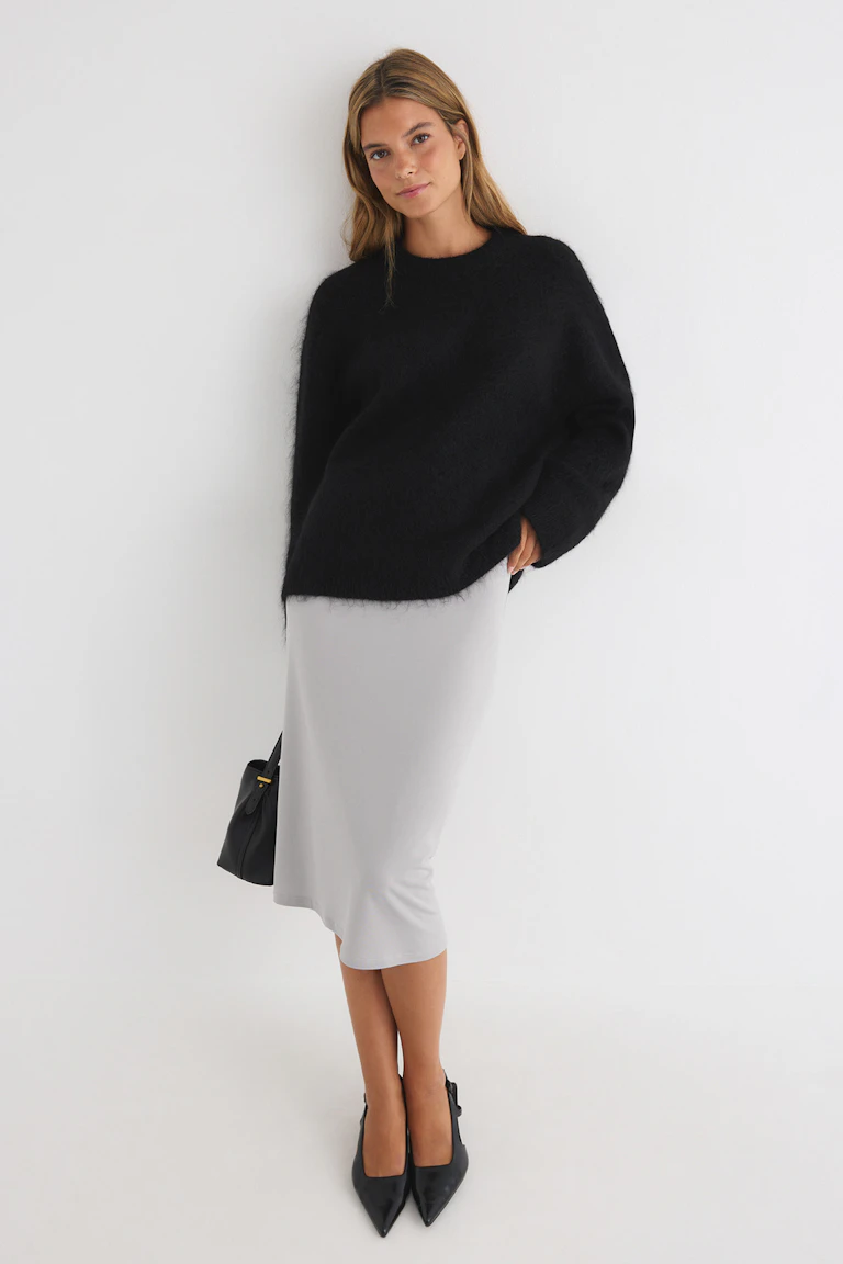 ID 329812, StyleColorSupplier 17900: Black fuzzy sweater, light grey midi skirt, and black pointed-toe heels.