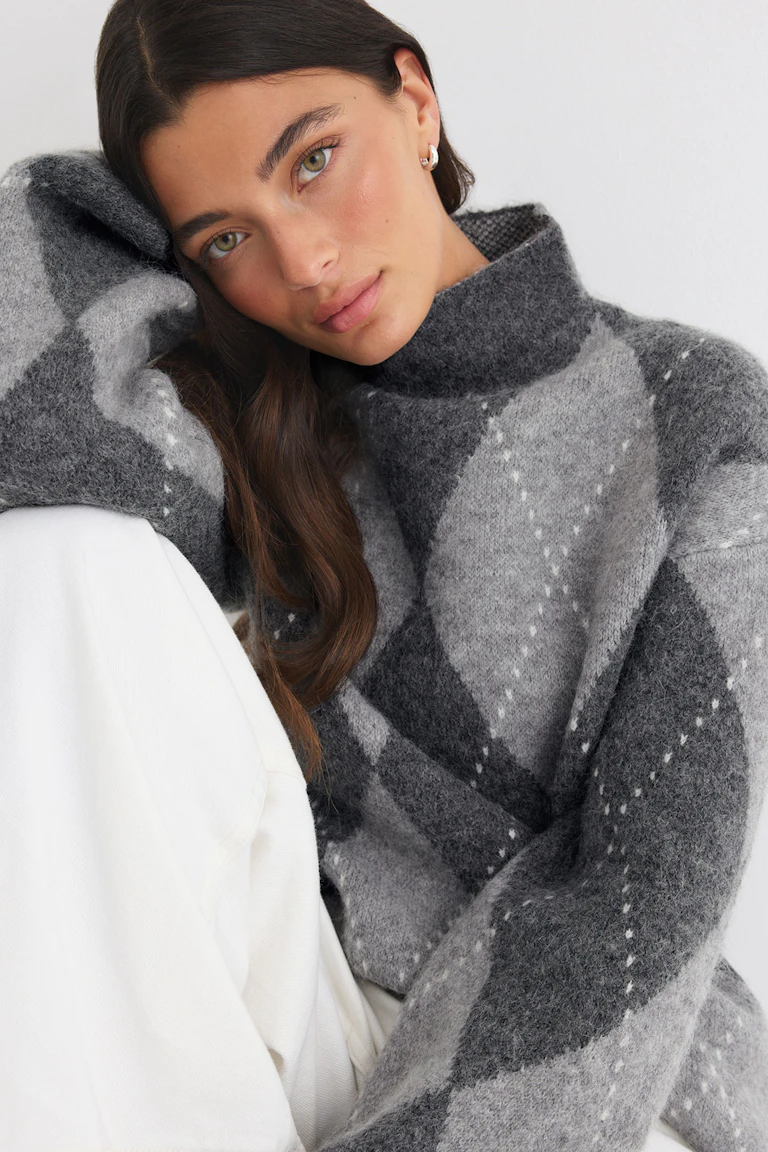 ID 331400, StyleColorSupplier 17900: Grau- und anthrazitfarbener Rollkragenpullover im Karomuster mit weißer Hose.