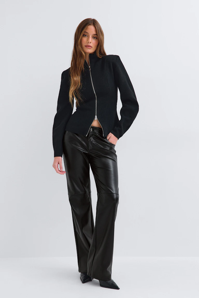 id: 335701; StyleColorSupplier: 14579. Schwarze, figurbetonte Jacke mit Reißverschluss vorne, schwarze Kunstlederhose und Stiefeletten mit spitzer Zehenpartie.
