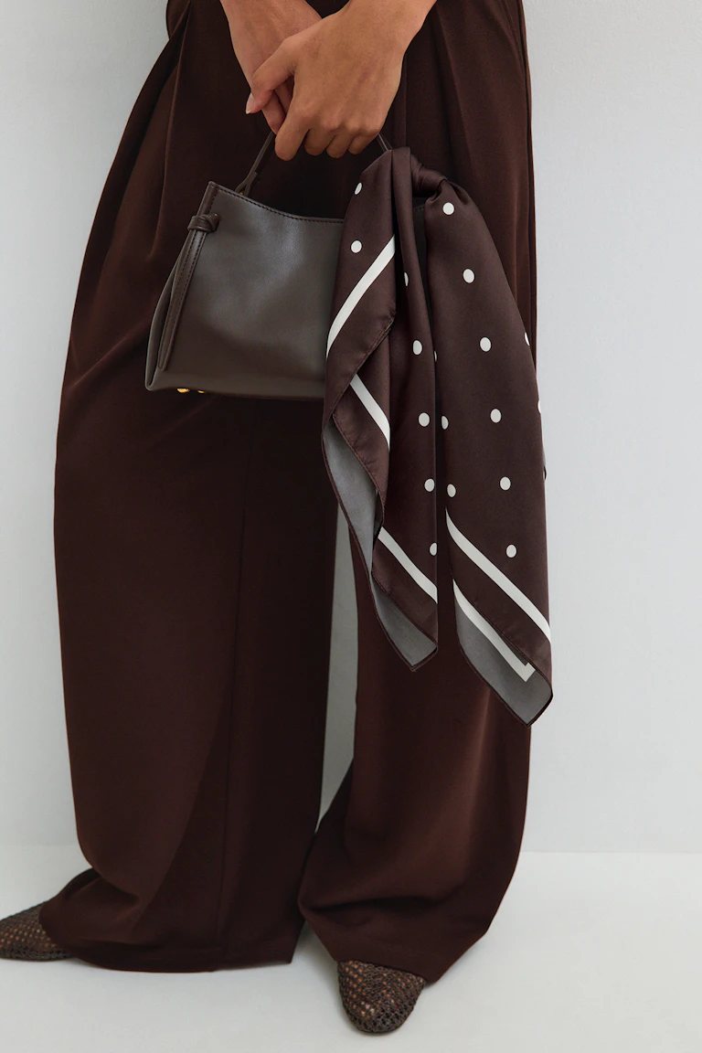 ID 325183: Dunkelbraune Hose mit weitem Bein, eine dazu passende Handtasche, ein brauner Schal mit Polka-Dots und geflochtene Ballerinas.