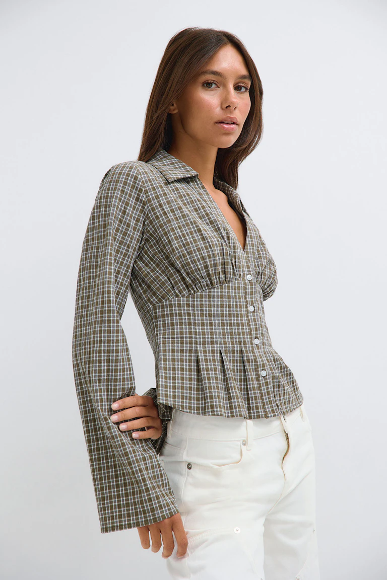 ID 327803 / StyleColorSupplier 14423: A plaid long-sleeve button-front peplum blouse with white trousers.