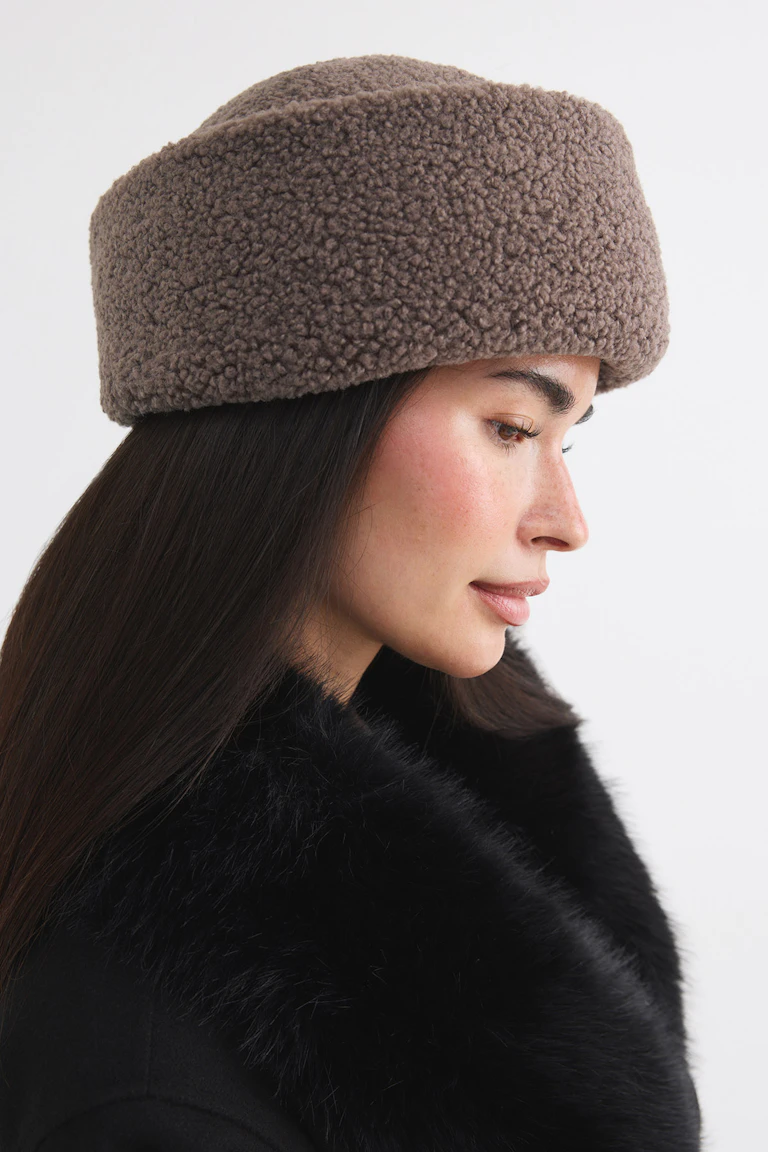 Brun hue i shearling-stil til en sort frakke i imiteret pels.