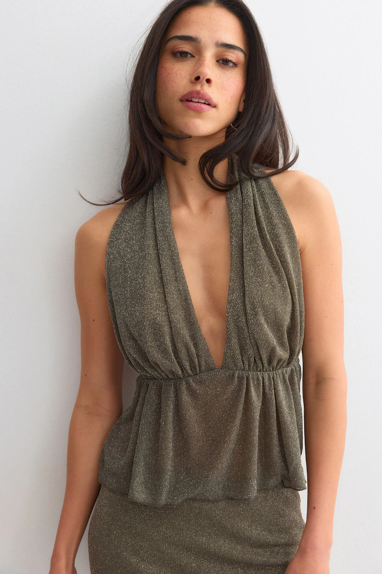 Sleeveless metallic olive-green halter dress with a deep plunging V-neck, gathered elastic waist and blouson peplum over a fitted skirt.