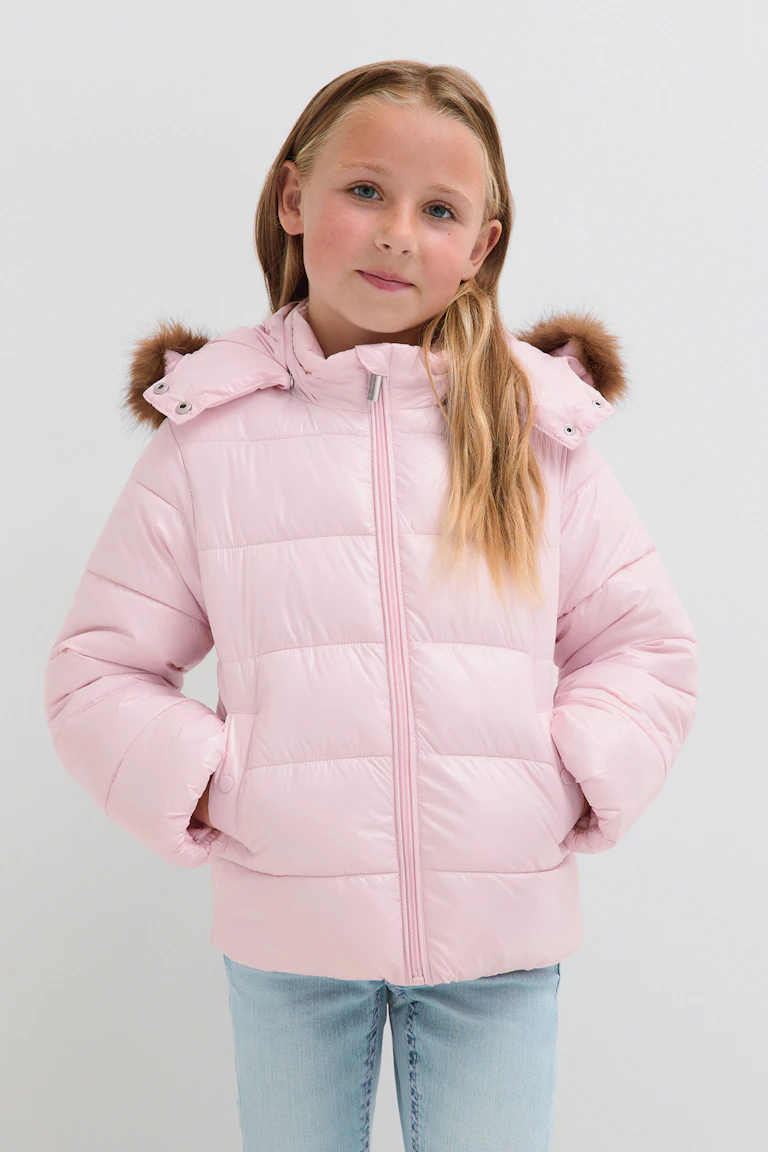 Eine hellrosa Steppjacke mit einer Kapuze mit Kunstfellbesatz und hellblaue Jeans.