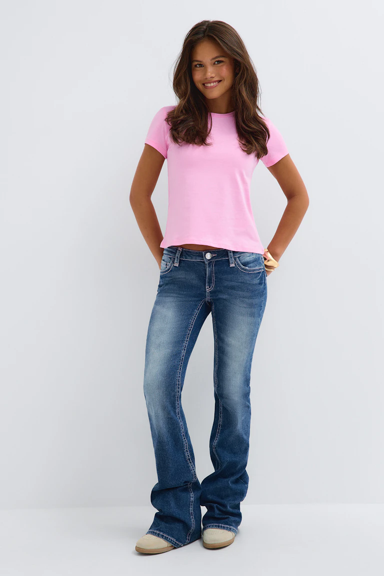 ID 331512, StyleColorSupplier 19021: en lyserød kortærmet bluse, blå jeans med udvidede ben og beige sko.