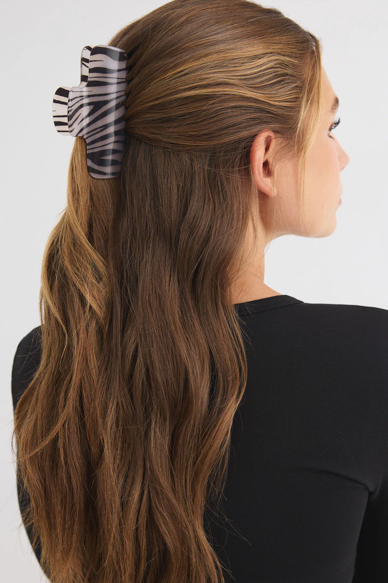 333404 | 19044: Schwarzes, figurbetontes Oberteil mit einer Haarspange mit Zebradruck.