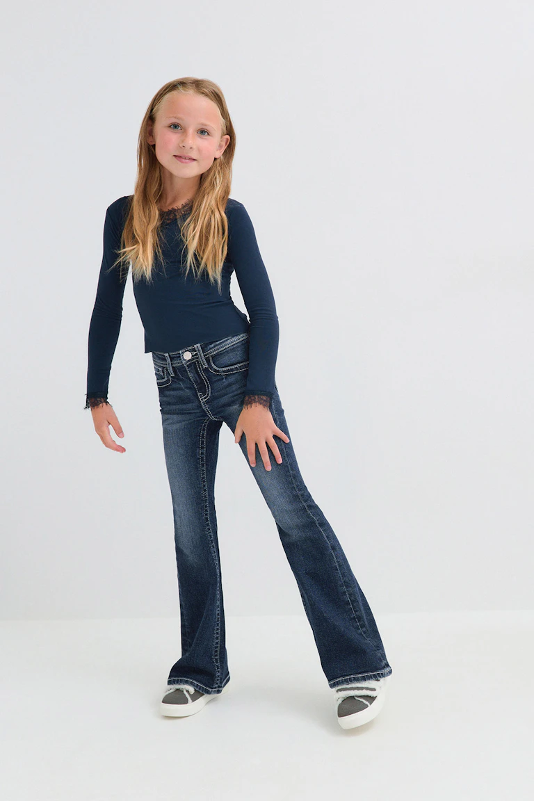ID 333388, StyleColorSupplier 19021: Marineblaues Langarm-Oberteil mit Spitzenbesatz, dunkle Schlagjeans und graue Slip-On-Sneaker.