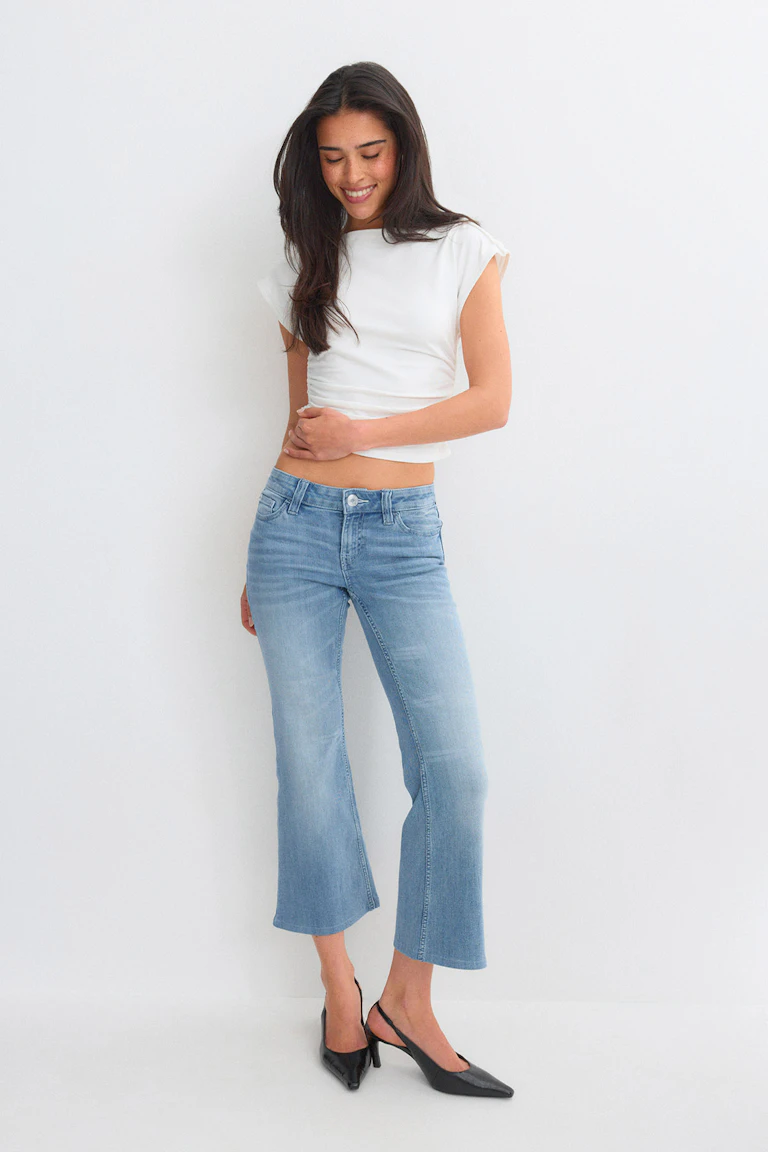 Hvid kortærmet cropped top med lyseblå cropped flared jeans og sorte spidse slingback-hæle.