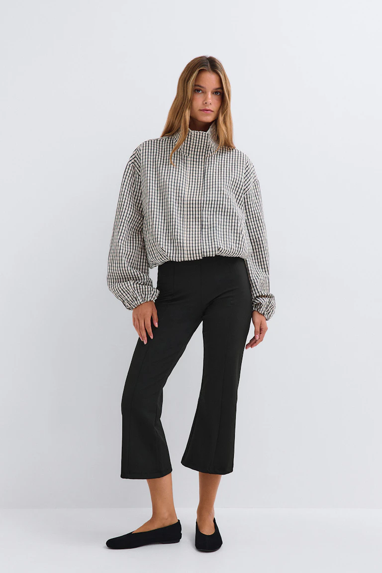 Mouwloze top met luipaardprint, gecombineerd met een zwarte cropped broek en zwarte sandalen met hak.