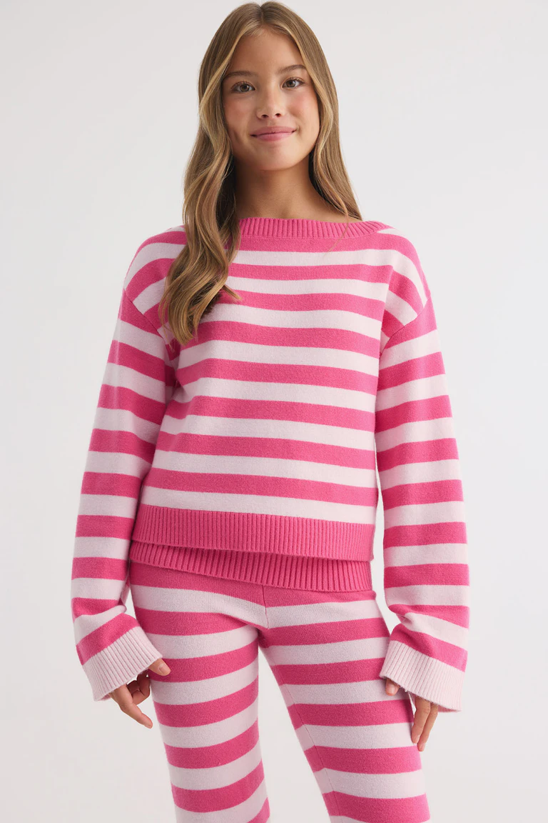 Pull en maille rayé rose et blanc, avec un pantalon assorti.